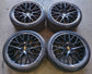 Four Porsche Panamera black multi-spoke wheels with machined lips, Porsche center caps and mounted Pirelli tires.