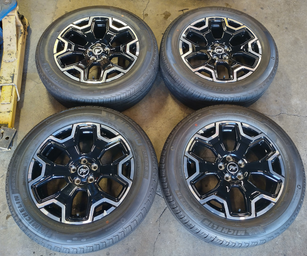 Four Ford Bronco Sport OEM 18-inch machined and gloss black wheels with Michelin tires and Bronco center caps.