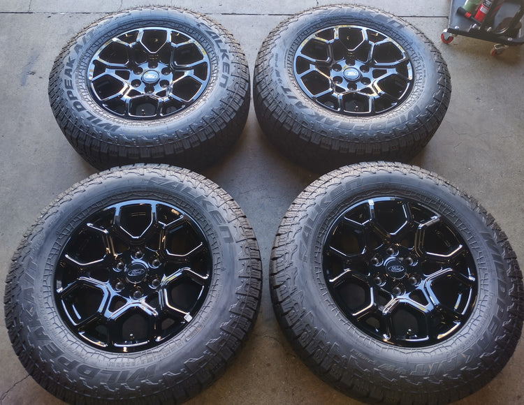 Four Ford F-150 OEM 18-inch gloss black wheels with Falken Wildpeak all-terrain tires and Ford center caps.