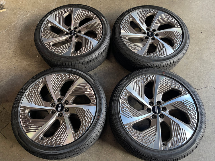 Four Lincoln Navigator 24-inch machined bronze OEM wheels with Goodyear tires and Lincoln center caps.