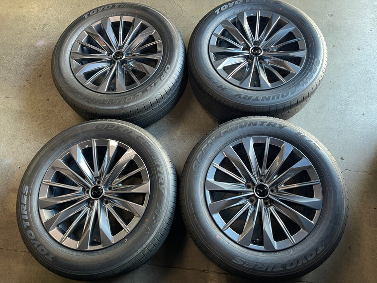 Set of four Mazda 19-inch Hyper Silver multi-spoke OEM wheels with Toyo Open Country H/T tires and Mazda center caps.