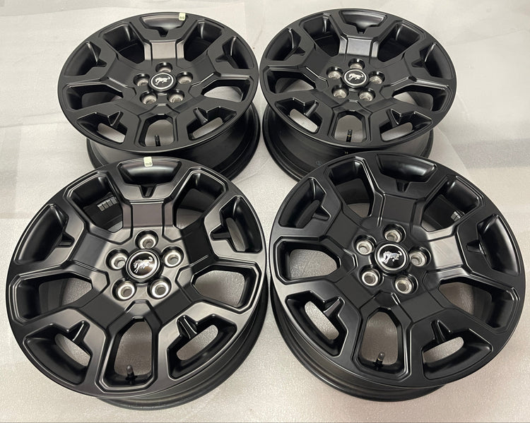 Set of 4 2026 Ford Bronco Sport OEM 17" semi gloss black wheels shown face up with Bronco center caps
