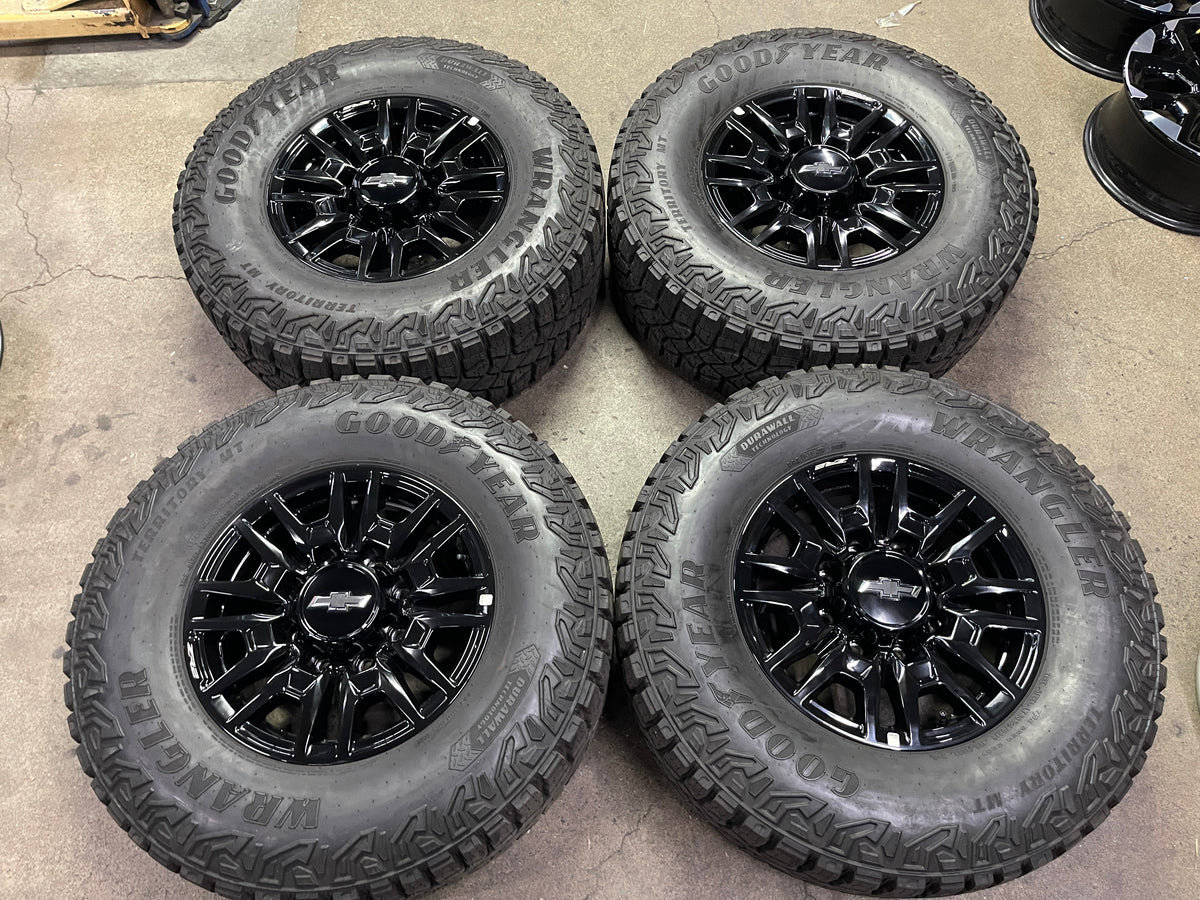 Four gloss-black Chevrolet Silverado ZR2 OEM wheels with Goodyear Wrangler Territory MT tires and Chevrolet center caps.