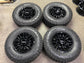 Four gloss-black Chevrolet Silverado ZR2 OEM wheels with Goodyear Wrangler Territory MT tires and Chevrolet center caps.