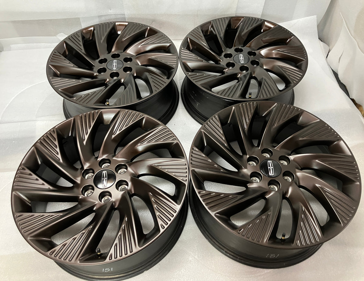Four Lincoln Navigator Black Label 22" OEM wheels in semi-gloss dark bronze with Lincoln center caps.